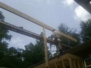 Carpenter setting a ridge beam over a new addition frame — Ice Dam Removal by Roofing Brothers in Beaver Meadows
