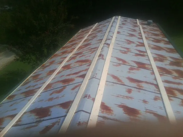 Rusted metal roof panels with new wood purlins before replacement — Storm Damage Roof Repair in Beaver Meadows by Roofing Brothers