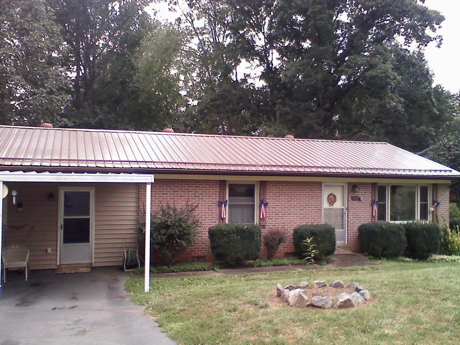 Bronze metal roof and carport on a brick ranch home — Roof Repair work by our crew in Beaver Meadows